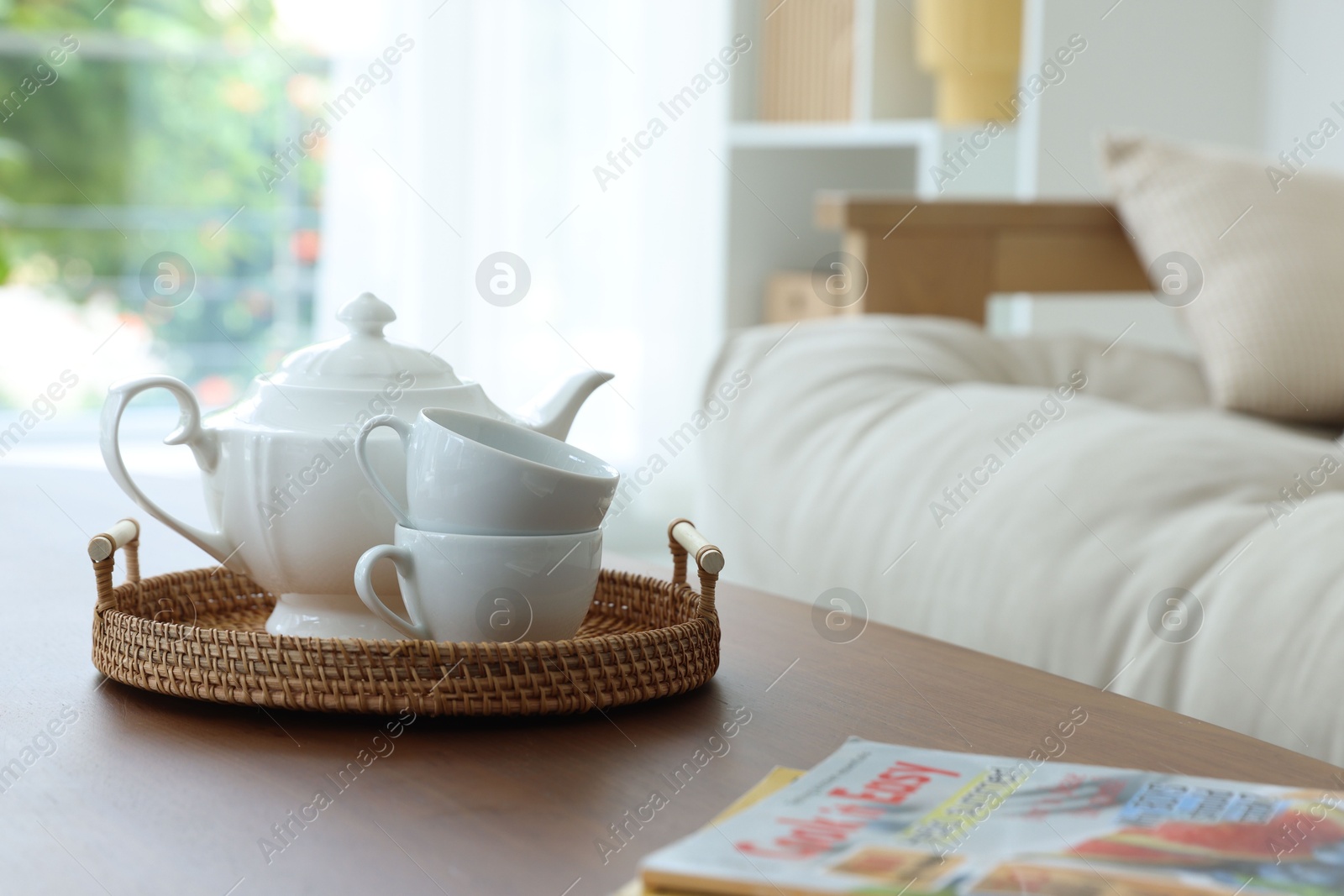 Photo of Teapot, cups and magazines on coffee table in dining room