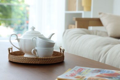 Photo of Teapot, cups and magazines on coffee table in dining room