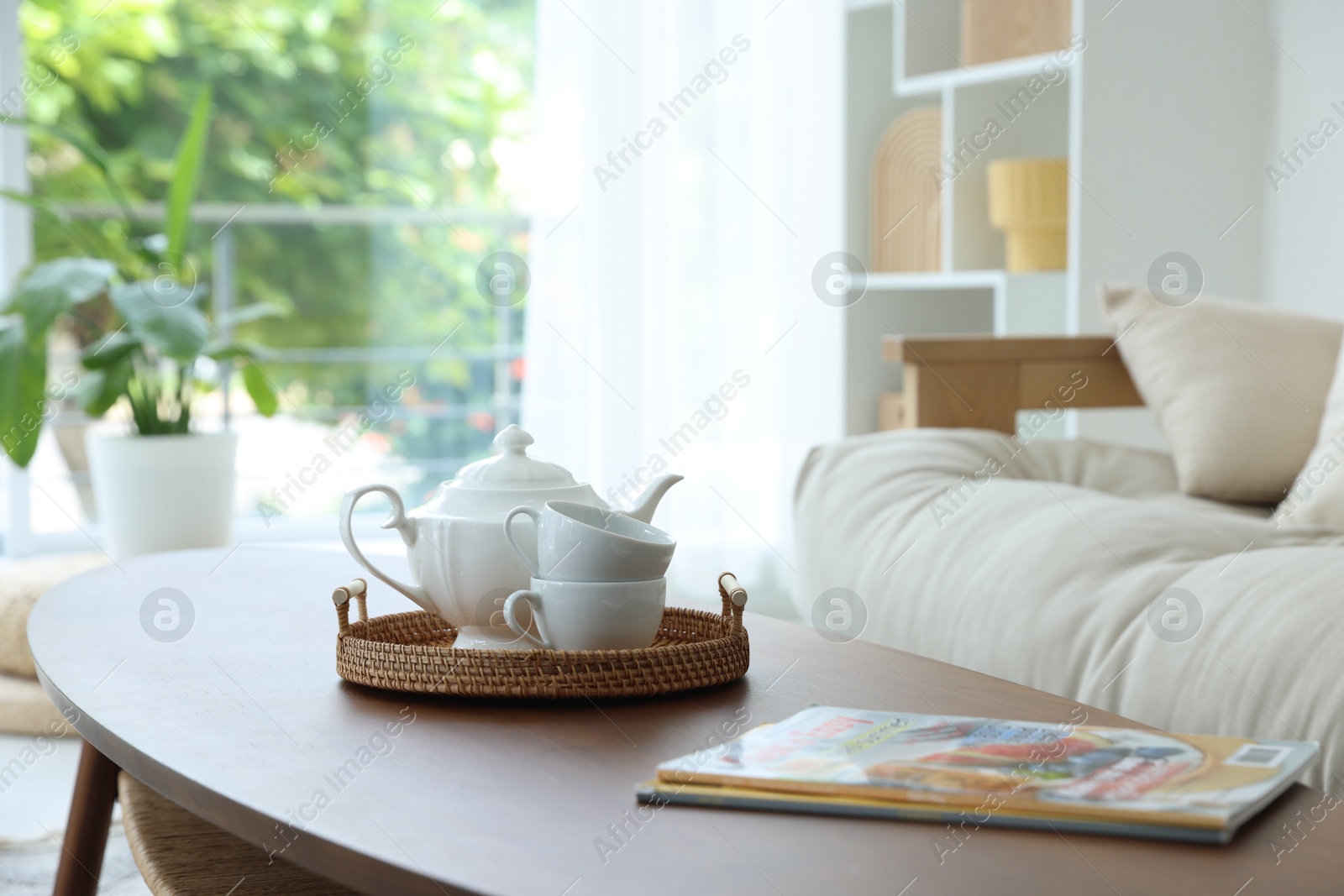 Photo of Teapot, cups and magazines on coffee table in dining room