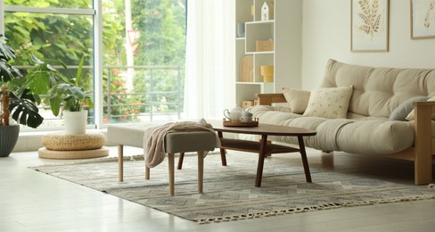 Photo of Coffee table, sofa, bench and decor in dining room. Interior design