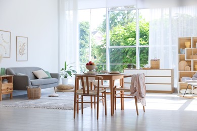 Photo of Stylish table setting, chairs and decor in dining room. Interior design