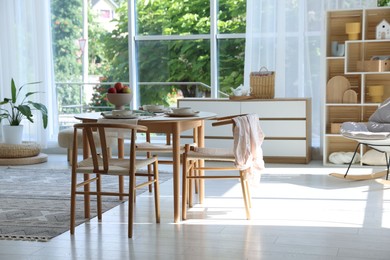Photo of Stylish table setting, chairs and decor in dining room. Interior design
