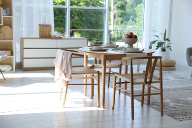 Photo of Stylish table setting, chairs and decor in dining room. Interior design