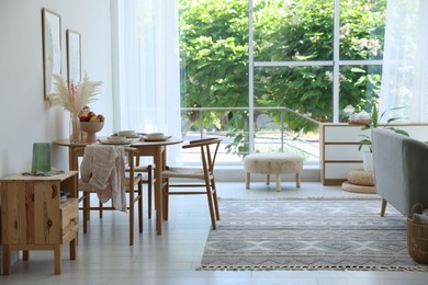 Photo of Stylish table setting, chairs and decor in dining room. Interior design