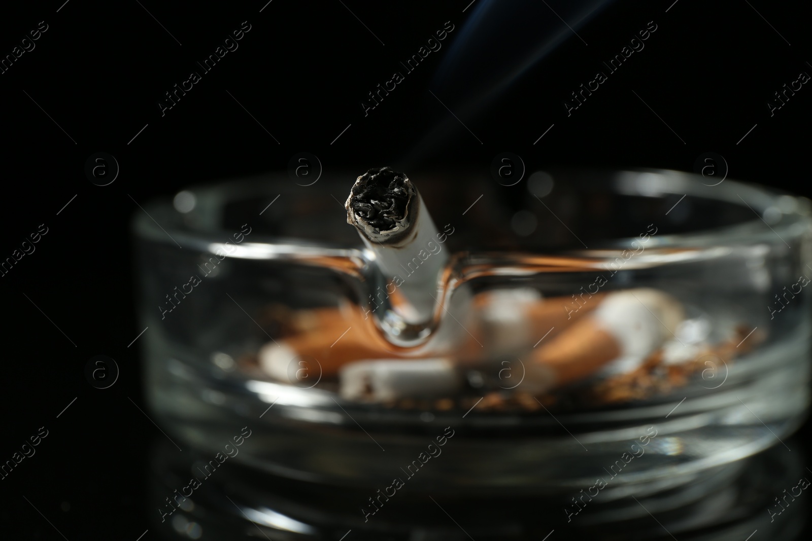 Cigarette butts in ashtray on black background, closeup Photo of Cigarette butts in ashtray on black background, closeup