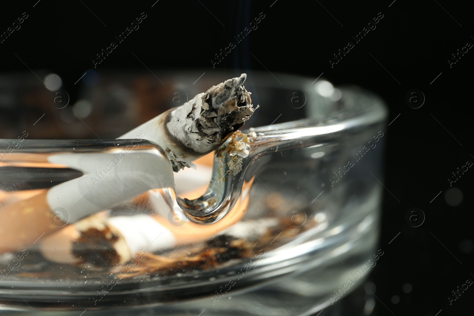 Cigarette butts in ashtray on black background, closeup Photo of Cigarette butts in ashtray on black background, closeup
