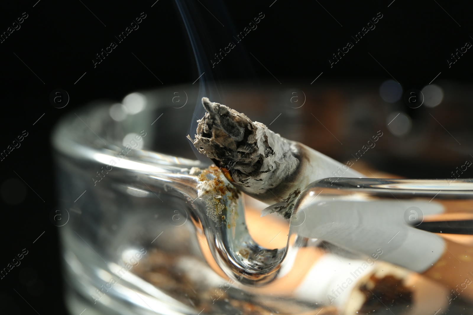 Cigarette butts in ashtray on black background, closeup Photo of Cigarette butts in ashtray on black background, closeup