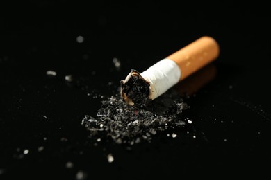 Photo of Cigarette butt with ash on black background, closeup