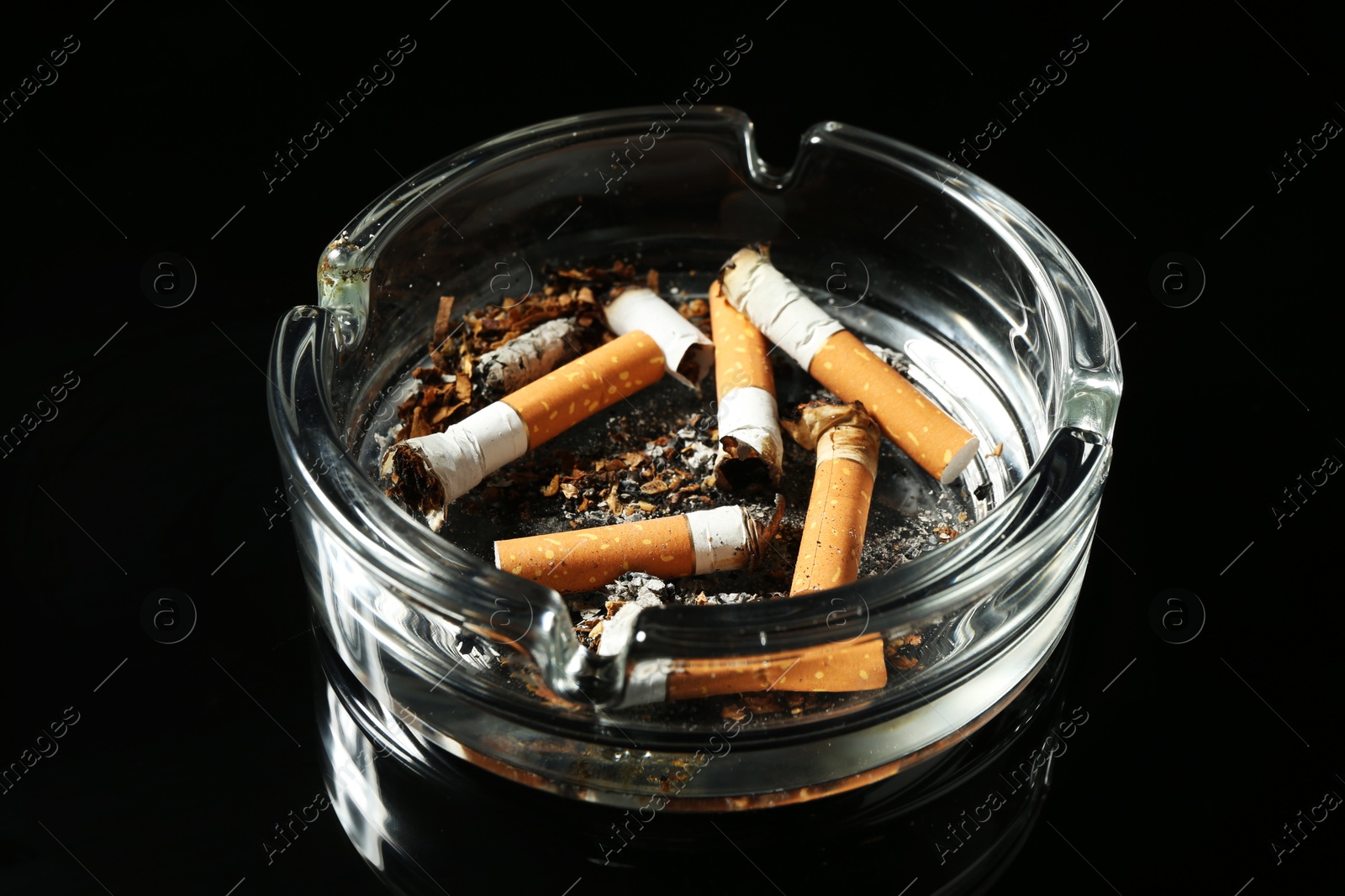 Cigarette butts in ashtray on black background, closeup Photo of Cigarette butts in ashtray on black background, closeup