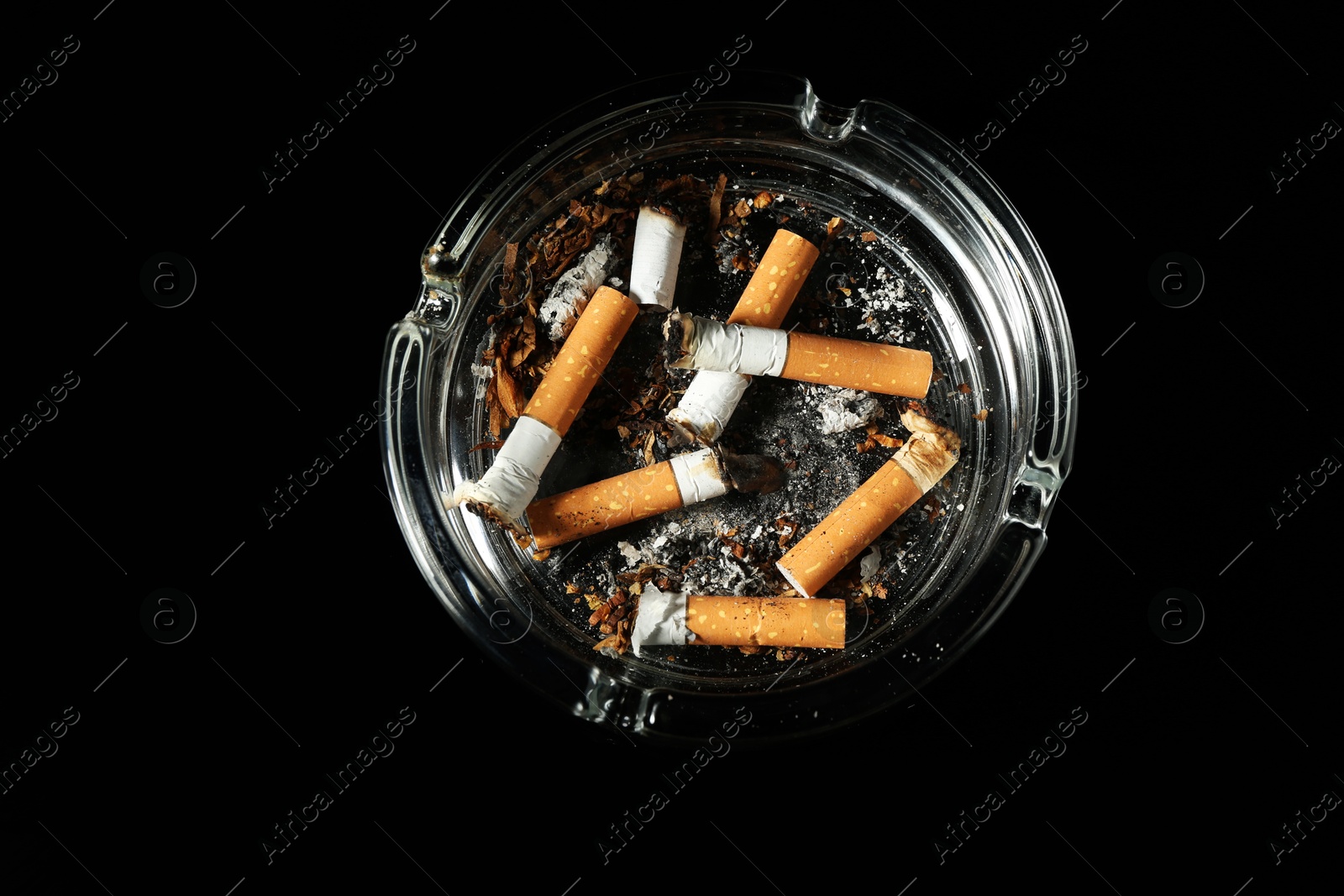 Cigarette butts in ashtray on black background, top view Photo of Cigarette butts in ashtray on black background, top view