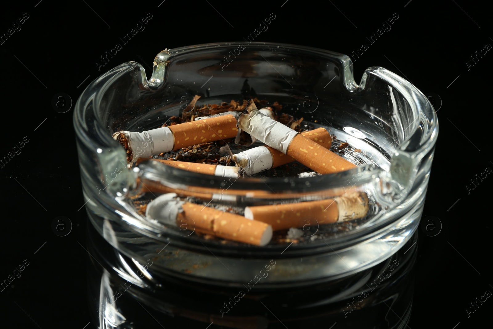 Cigarette butts in ashtray on black background, closeup Photo of Cigarette butts in ashtray on black background, closeup