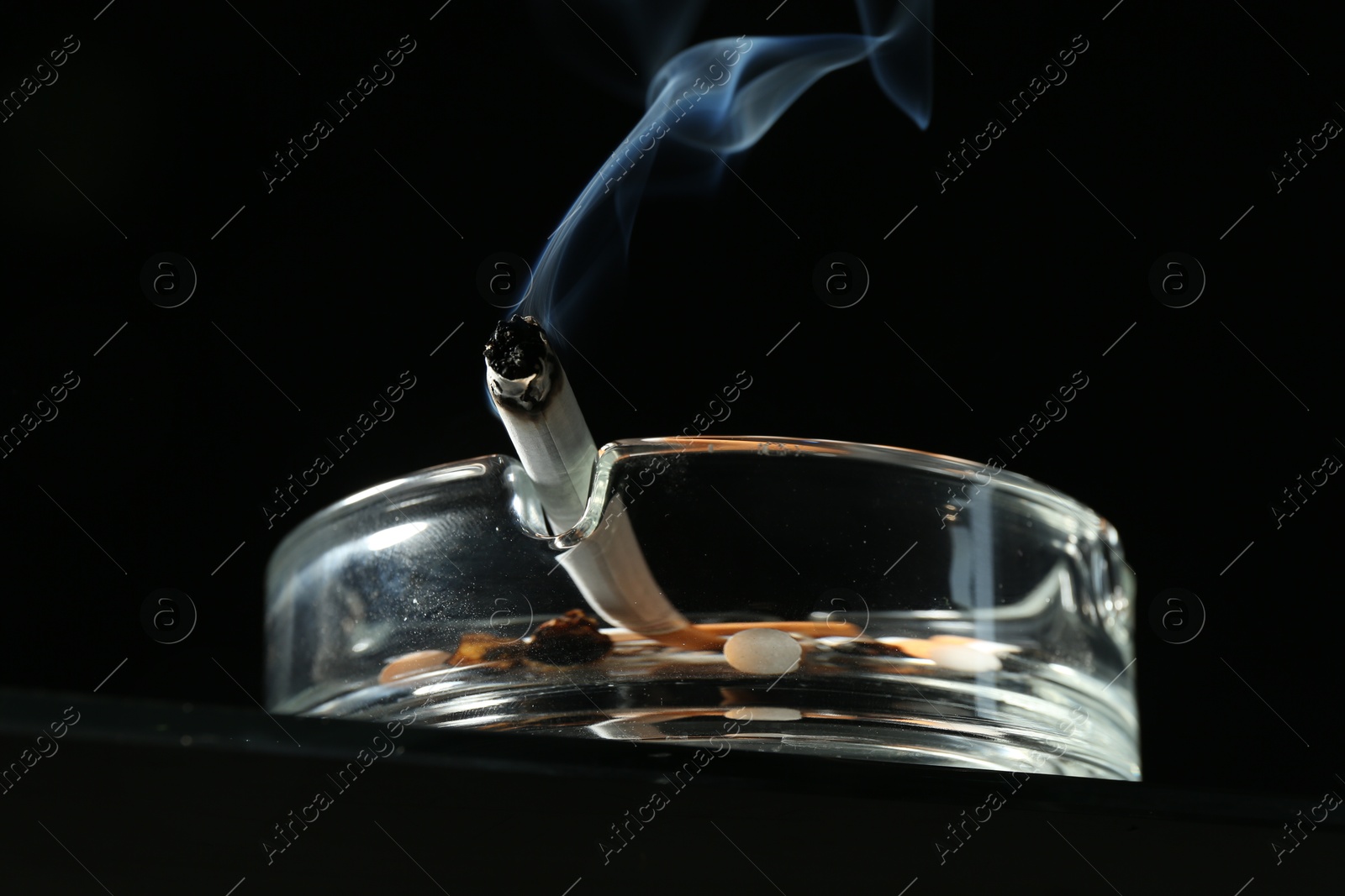 Cigarette butts in ashtray on black background, closeup Photo of Cigarette butts in ashtray on black background, closeup