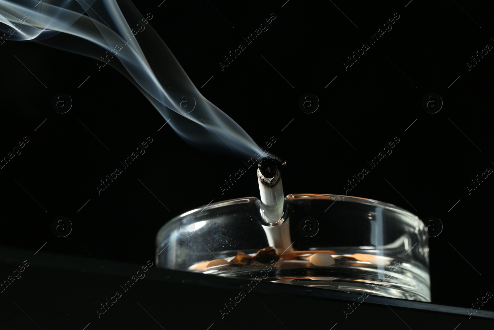 Cigarette butts in ashtray on black background, closeup Photo of Cigarette butts in ashtray on black background, closeup