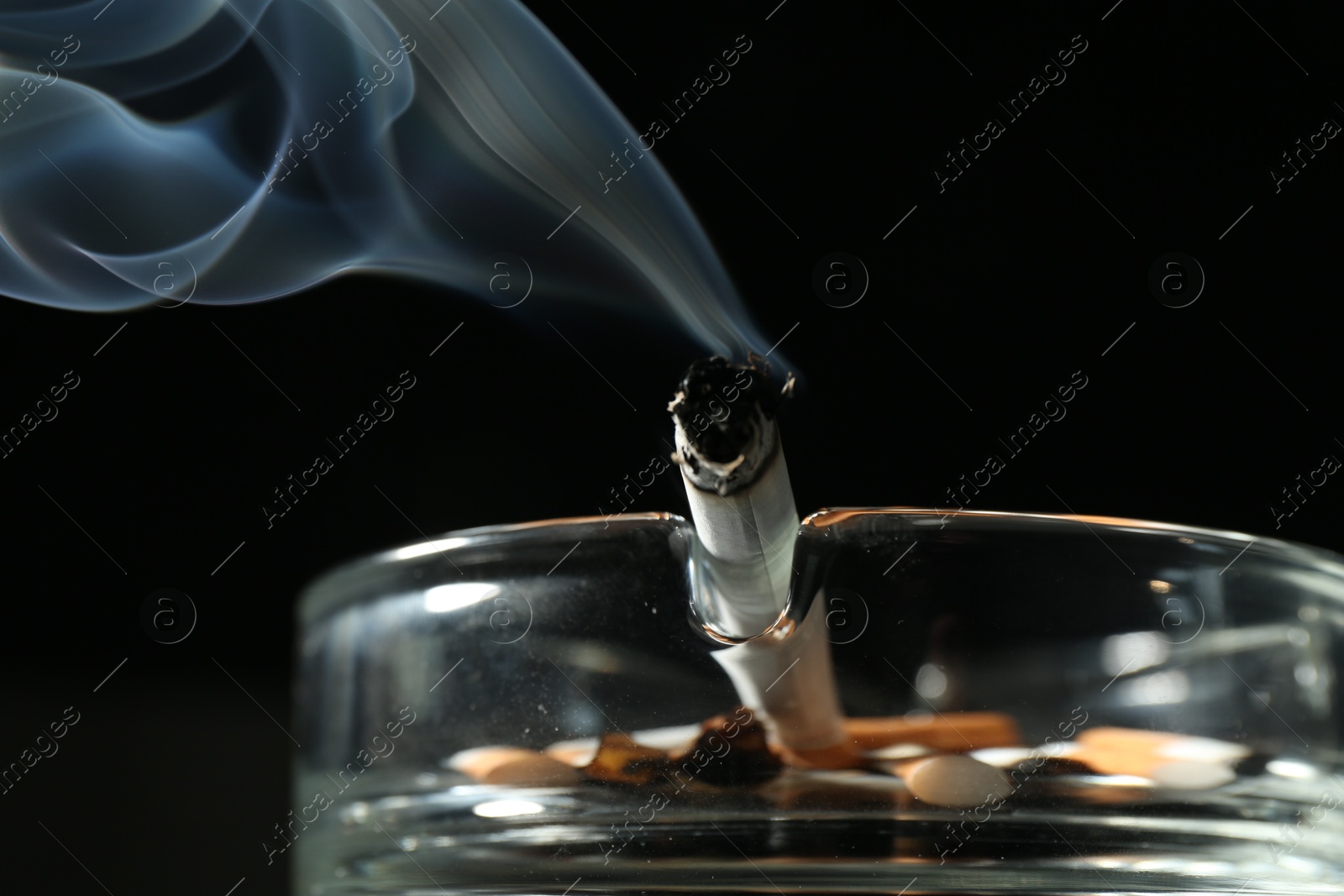 Cigarette butts in ashtray on black background, closeup Photo of Cigarette butts in ashtray on black background, closeup