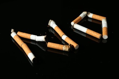 Photo of Word NO made with cigarette butts on black background