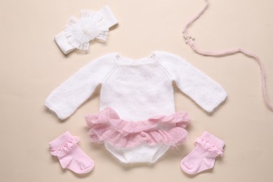 Photo of Baby clothes and accessories on beige background, flat lay