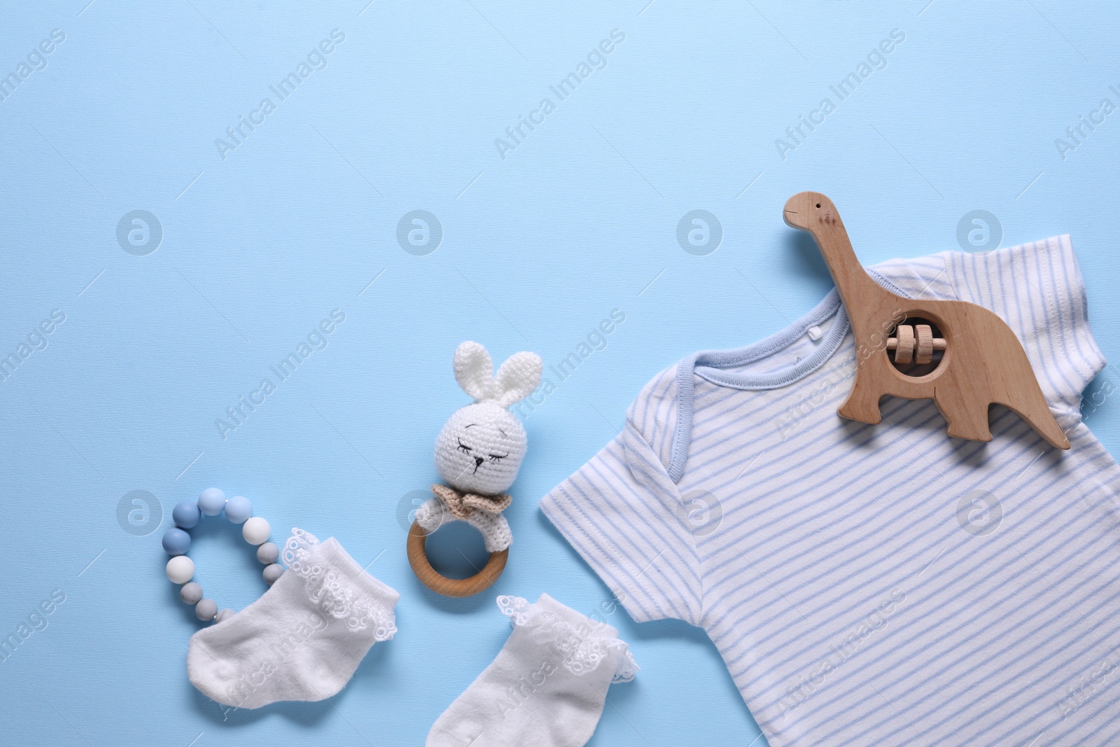 Baby clothes and accessories on light blue background, flat lay Photo of Baby clothes and accessories on light blue background, flat lay