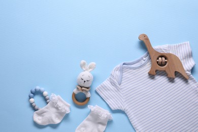 Photo of Baby clothes and accessories on light blue background, flat lay