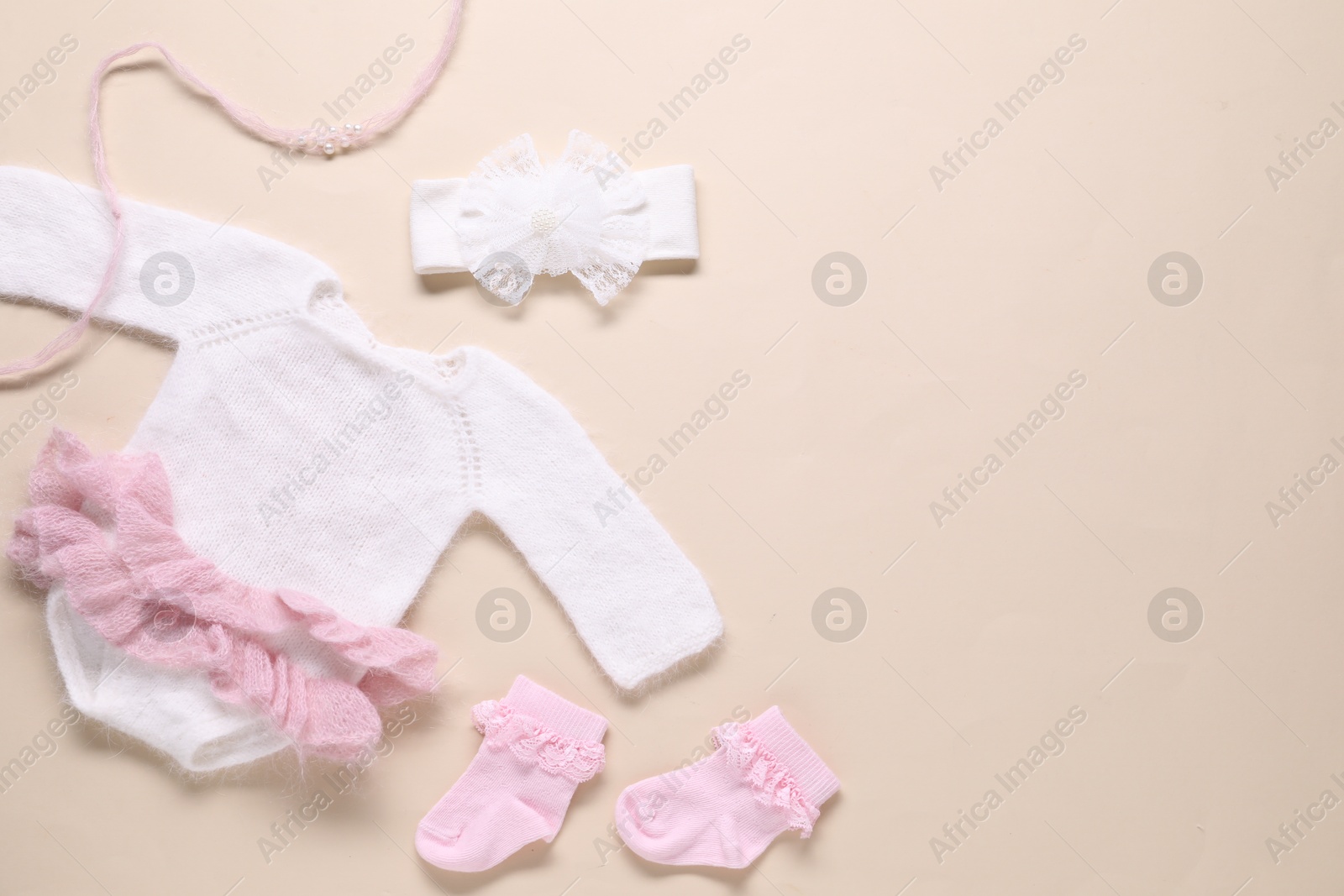 Baby clothes and accessories on beige background, flat lay. Space for text Photo of Baby clothes and accessories on beige background, flat lay. Space for text
