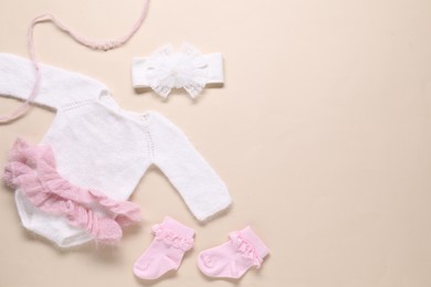 Photo of Baby clothes and accessories on beige background, flat lay. Space for text