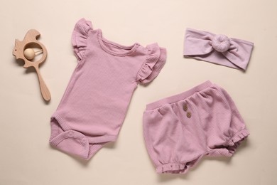 Photo of Baby clothes and accessories on beige background, flat lay