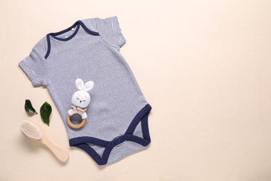 Photo of Baby onesie and accessories on beige background, flat lay. Space for text