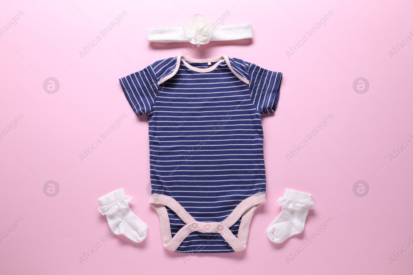 Baby clothes and accessories on pink background, flat lay Photo of Baby clothes and accessories on pink background, flat lay