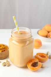 Photo of Superfood. Tasty smoothie and ingredients on white table, closeup