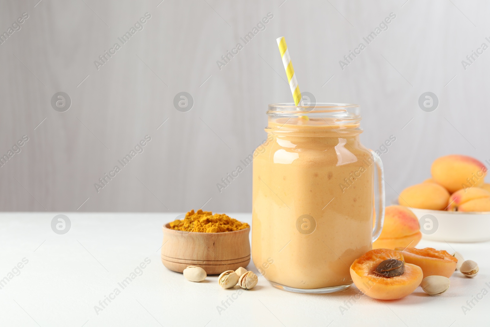 Superfood. Tasty smoothie and ingredients on white table, space for text Photo of Superfood. Tasty smoothie and ingredients on white table, space for text