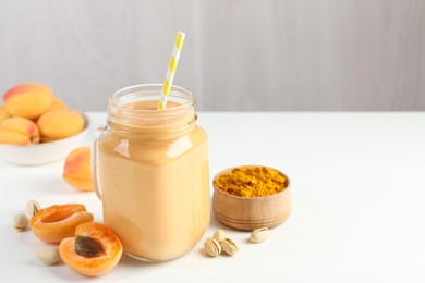 Photo of Superfood. Tasty smoothie and ingredients on white table, closeup. Space for text
