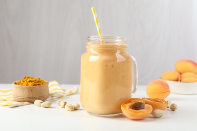 Photo of Superfood. Tasty smoothie and ingredients on white table