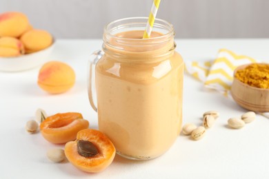 Photo of Superfood. Tasty smoothie and ingredients on white table, closeup