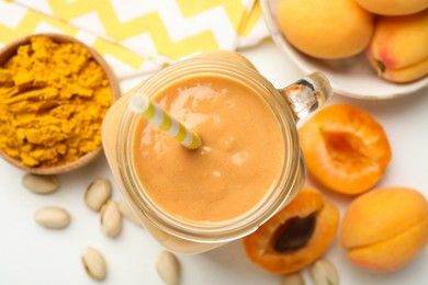 Photo of Superfood. Tasty smoothie and ingredients on white table, flat lay