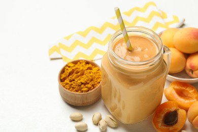 Photo of Superfood. Tasty smoothie and ingredients on white table, closeup. Space for text
