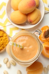Photo of Superfood. Tasty smoothie and ingredients on white table, flat lay