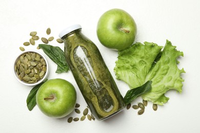 Photo of Superfood. Tasty smoothie in glass bottle and ingredients on white table, flat lay