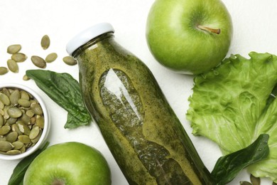 Photo of Superfood. Tasty smoothie in glass bottle and ingredients on white table, flat lay