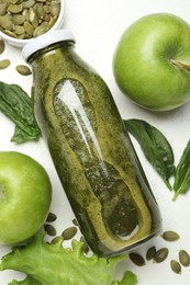 Photo of Superfood. Tasty smoothie in glass bottle and ingredients on white table, flat lay