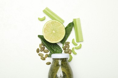 Photo of Superfood. Tasty smoothie in glass bottle and ingredients on white table, flat lay