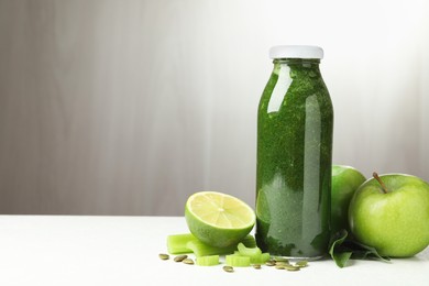 Photo of Superfood. Tasty smoothie in glass bottle and ingredients on white table, space for text
