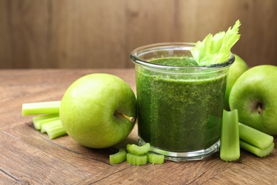 Photo of Superfood. Tasty smoothie in glass and ingredients on wooden table, closeup