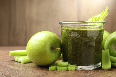 Photo of Superfood. Tasty smoothie in glass and ingredients on wooden table, closeup