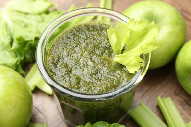 Photo of Superfood. Tasty smoothie in glass and ingredients on wooden table, closeup