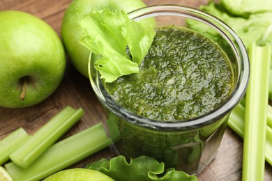 Photo of Superfood. Tasty smoothie in glass and ingredients on wooden table, closeup