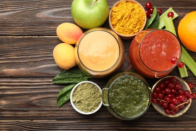 Photo of Superfood. Tasty smoothies in glasses and ingredients on wooden table, flat lay. Space for text