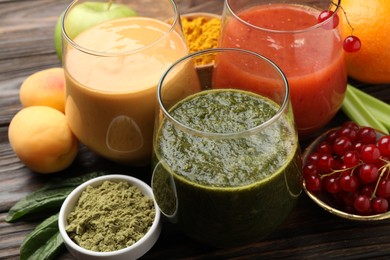 Photo of Superfood. Tasty smoothies in glasses and ingredients on wooden table, closeup