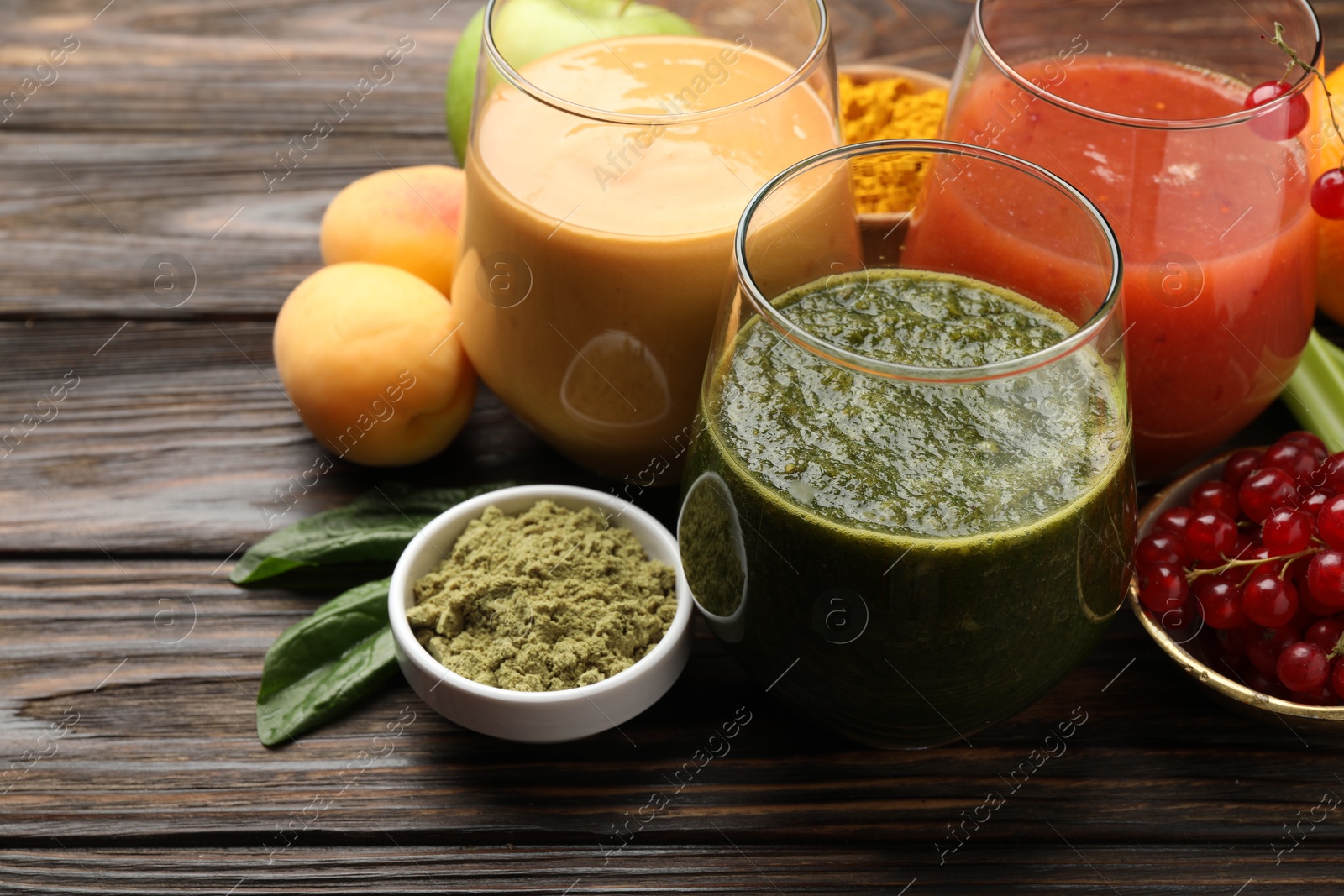Superfood. Tasty smoothies in glasses and ingredients on wooden table, closeup Photo of Superfood. Tasty smoothies in glasses and ingredients on wooden table, closeup