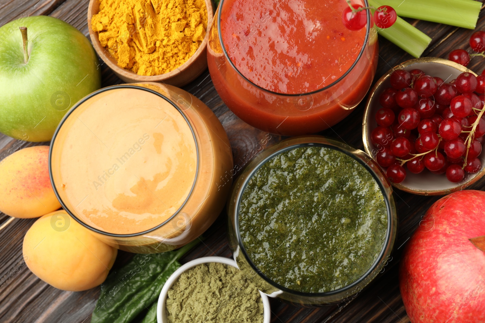 Superfood. Tasty smoothies in glasses and ingredients on wooden table, flat lay Photo of Superfood. Tasty smoothies in glasses and ingredients on wooden table, flat lay