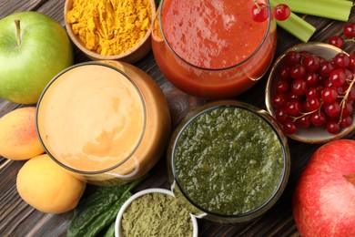 Photo of Superfood. Tasty smoothies in glasses and ingredients on wooden table, flat lay