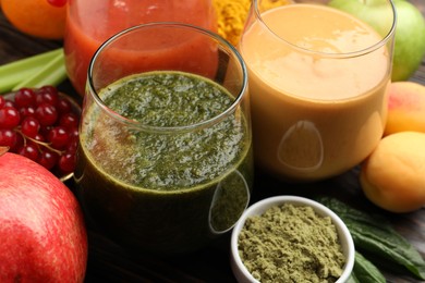 Photo of Superfood. Tasty smoothies in glasses and ingredients on table, closeup